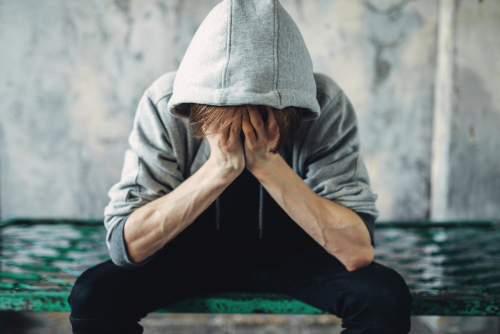 person sitting with head in their hands