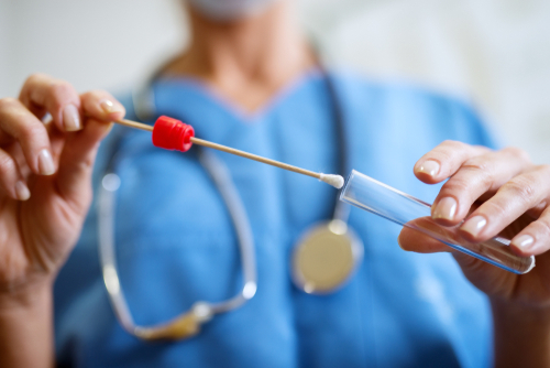 woman inserting swab into test tube