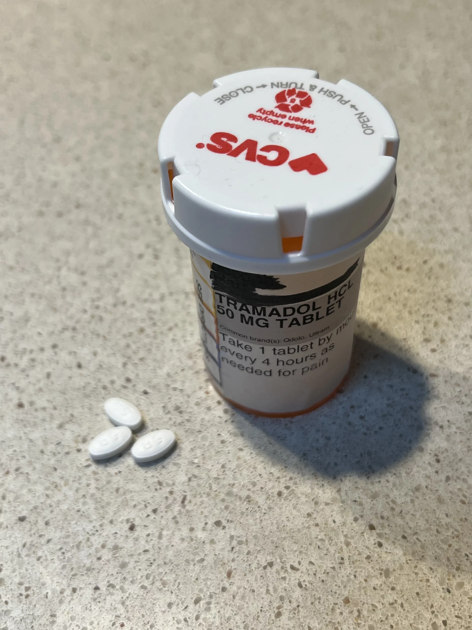 tramadol pill bottle with 3 pills on counter next to bottle