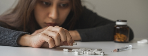 woman picking up pills wondering: can tramadol get you high?