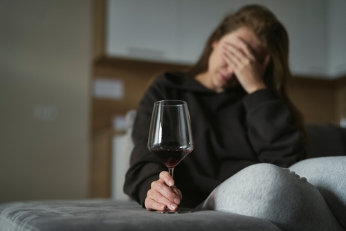 woman holding a glass of wine while being a alcoholic