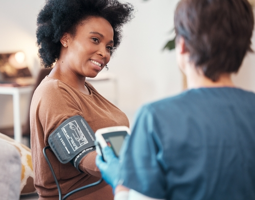 woman having her blood pressure checkec