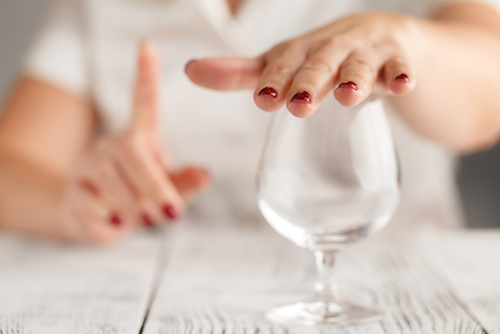 woman holding hand over glass